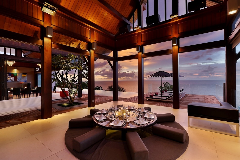 An image of an outdoor sala with a sunken dining lounge set for dinner.