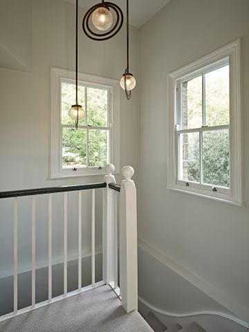 Bella figura bronze halo pendants hanging over staircase.