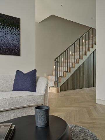 Open plan living entrance hallway view where there is a staircase in the back and living area in front.