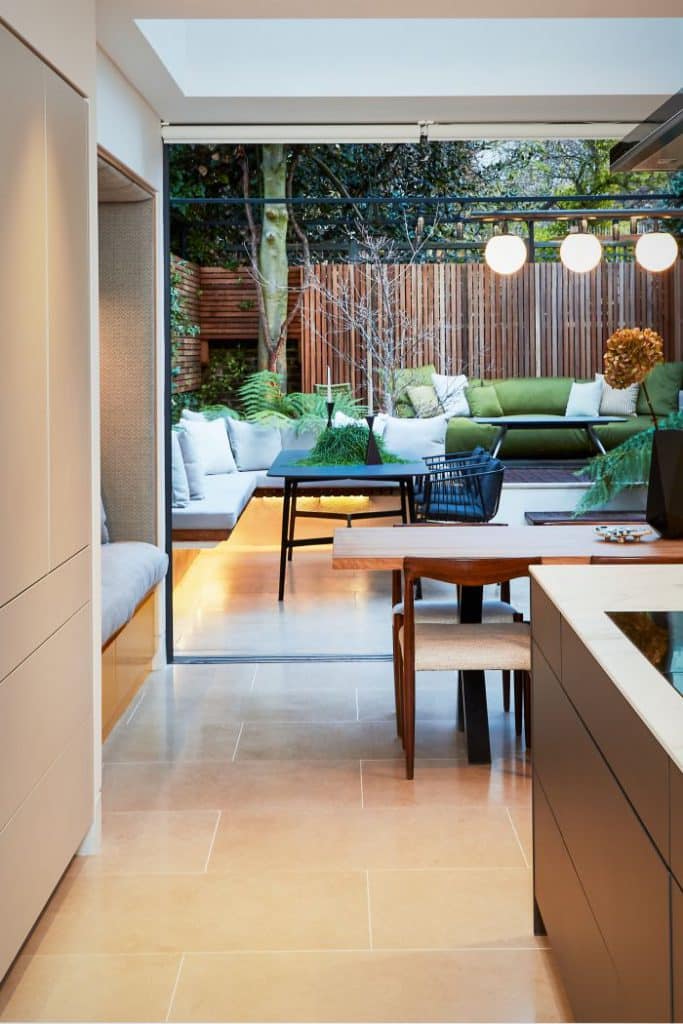 An urban garden fit for indoor-outdoor living and dining with natural stone flooring.