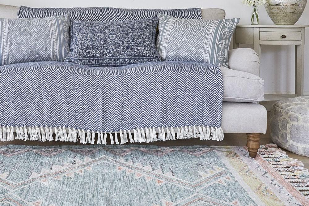 Andalucia paloma rug with a grey sofa on top of it.