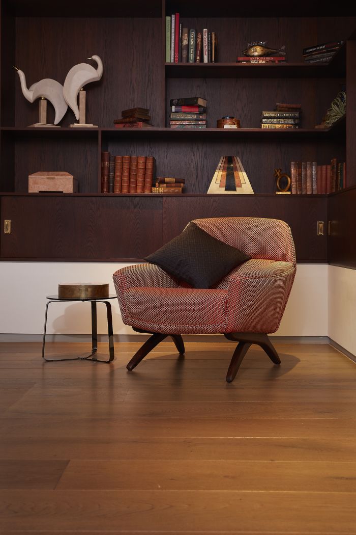An antique armchair sits in the corner of the library area in the principle bedroom. 