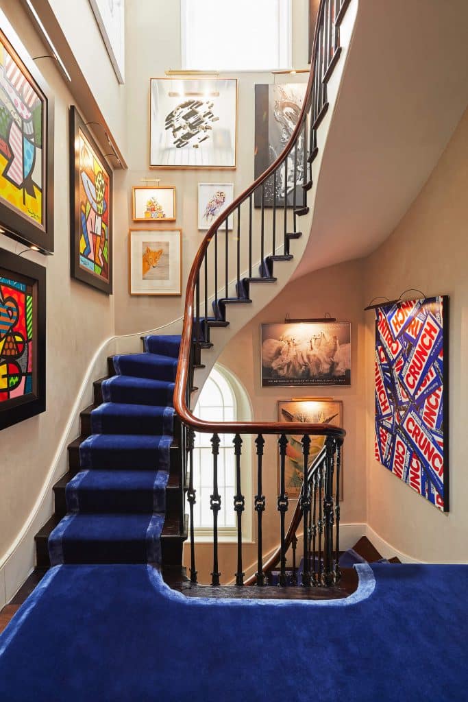 Art gallery staircase with blue carpet leading up in Period home.