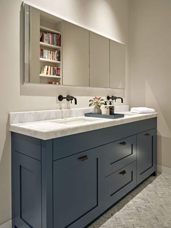 An ensuite bathroom with double hague blue vanity and white marble counter top.