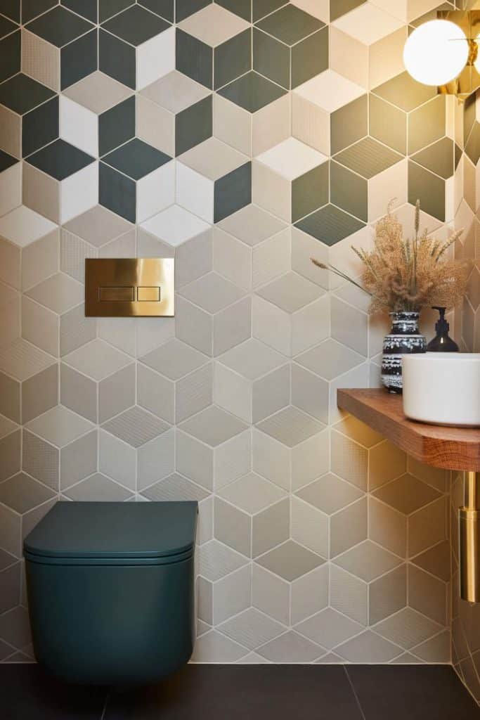 Geometric tile on guest bathroom wall with brass taps.