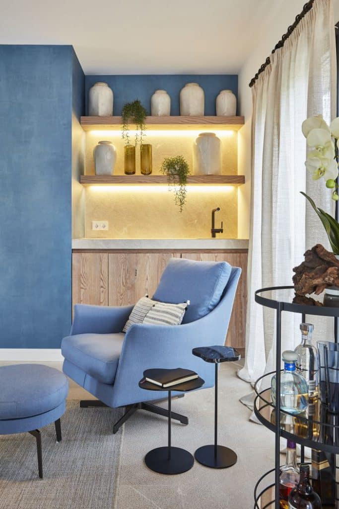 A stone and wood living room bar with flexform boss armchair in blue.