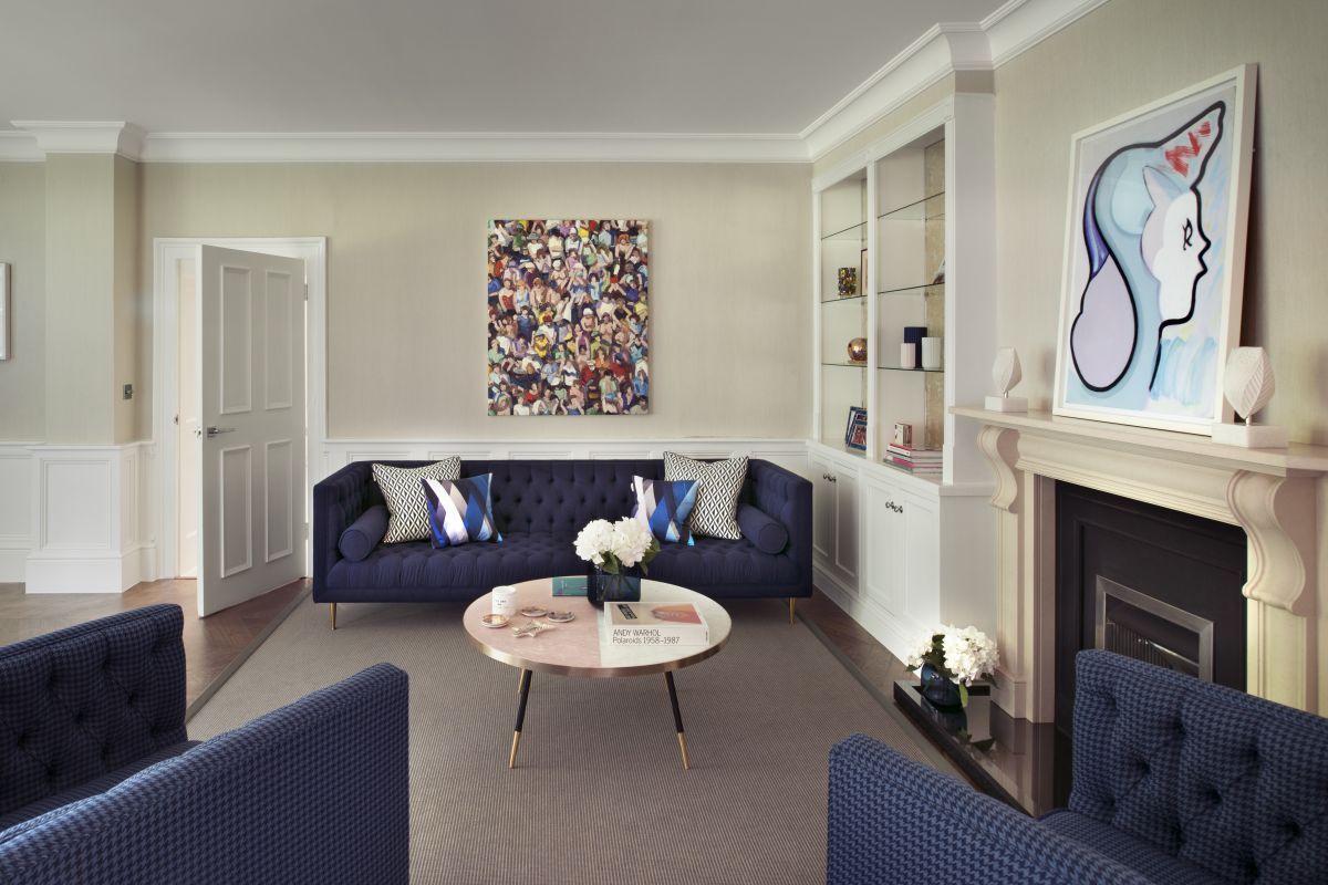 A living room with blue sofas and neutral walls designed by Simone Suss of Studio Suss.