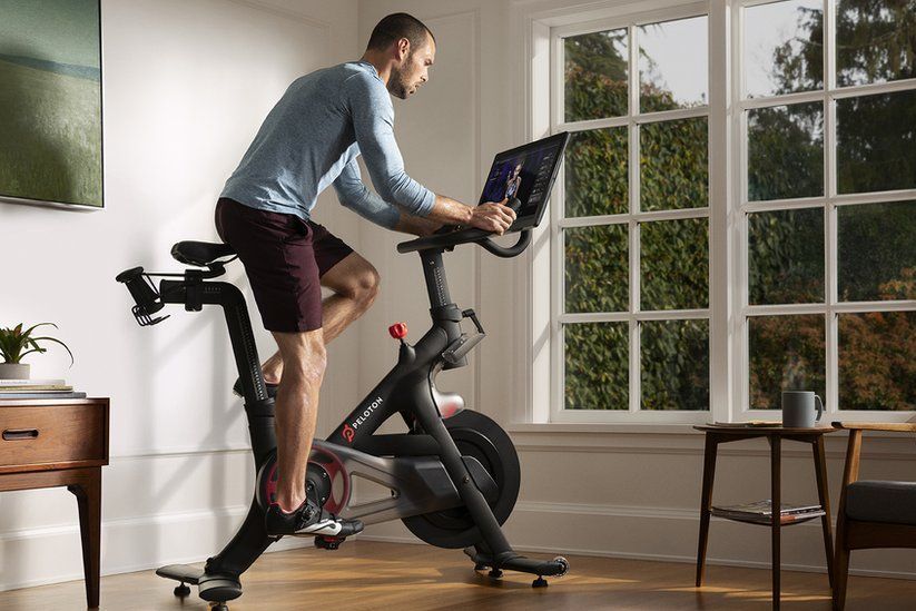Man using a pelaton bike in his luxury home gym