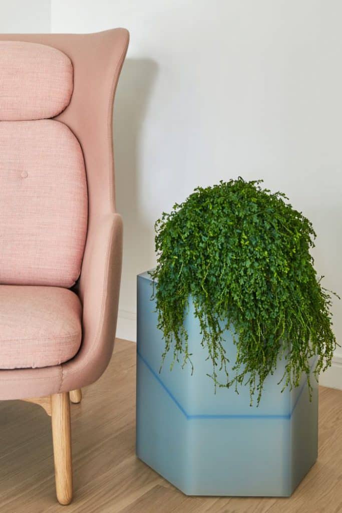 A resin sidetable by fracture studio and an armchair in pink by Fritz Hansen.