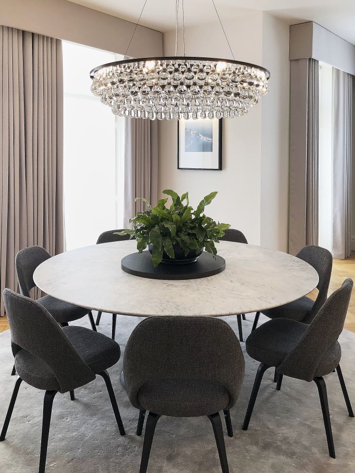 A restoration hardware marble dining table sits beautifully under an Artic Pear chandelier by Ochre.