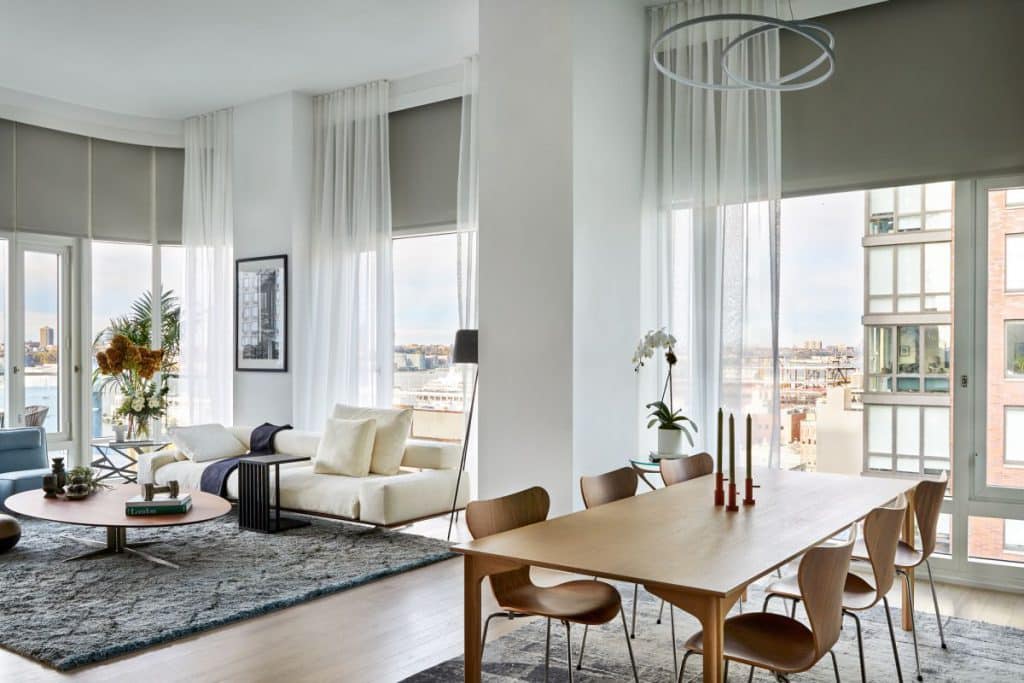 open space in Manhattan penthouse. Both in dining area and living space stark silk rugs are located.