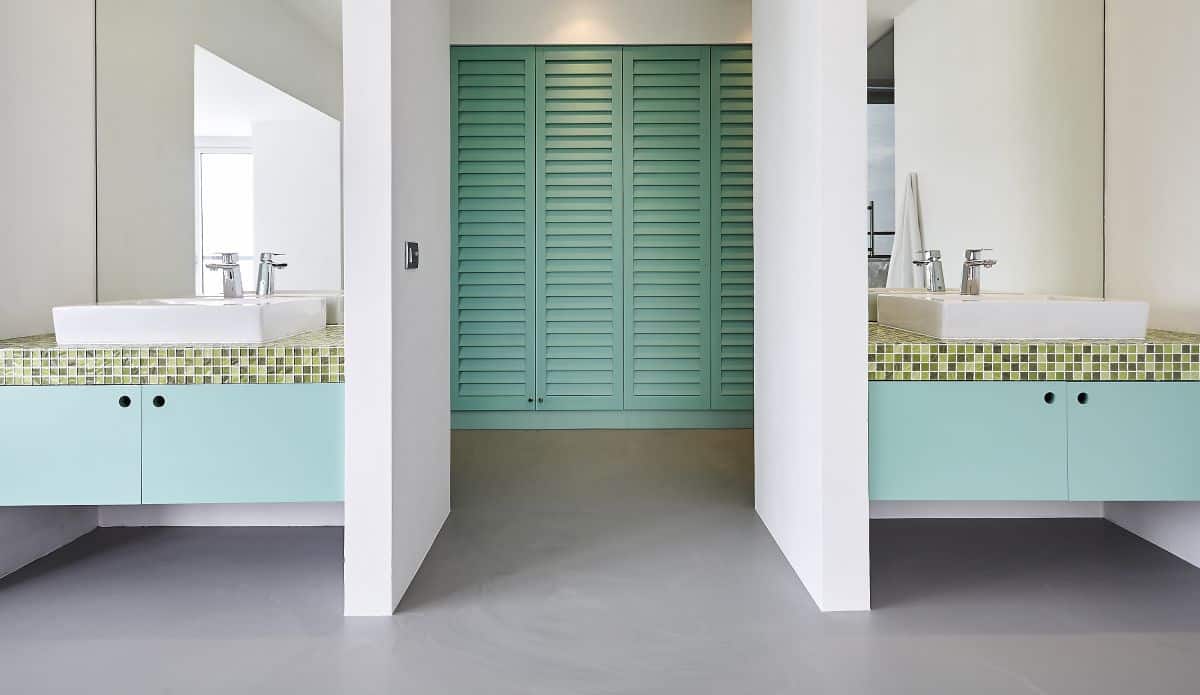 A teal and crisp white coloured double vanity bathroom and walk in wardrobe. 