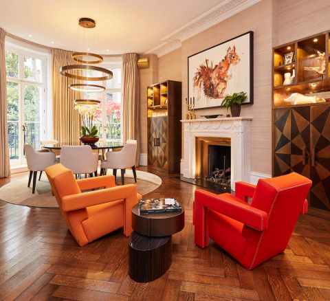 A pair of orange and red cassina utrecht armchairs in period London property in front of fireplace.