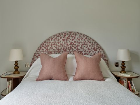 Neutral bedroom with pink headboard and cushions inspired by Soho House.