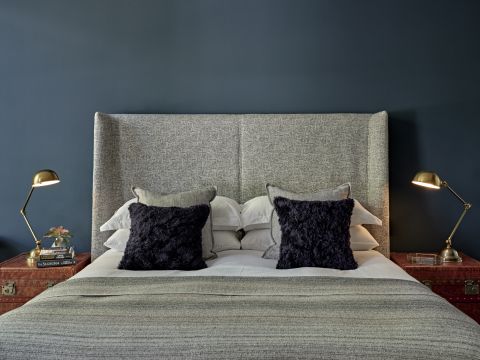 Hague blue bedroom with modern wingback headboard and blue walls.