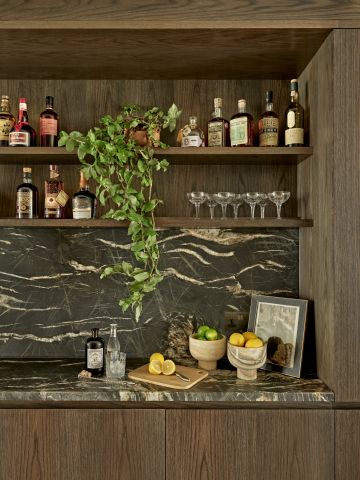Wooden and marble home luxury bar decorated with botanicals and bar essentials.
