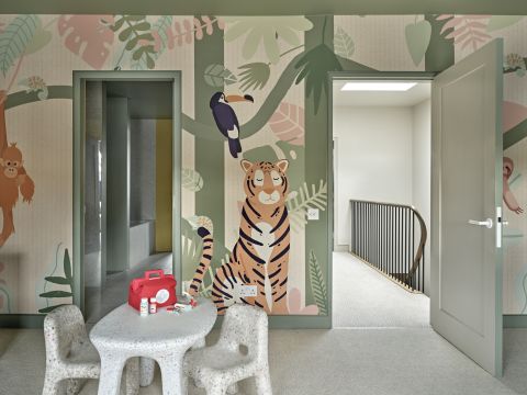 Playful kids playroom and bedroom with jungle explorer themed wallpaper.