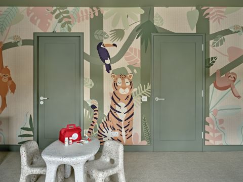Playful kids playroom and bedroom with jungle print wallpaper.