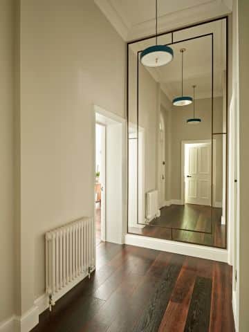 Large custom mirror with bronze frame in period property hallway.