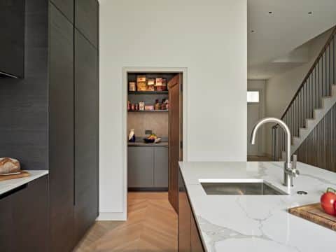 neutral minimalistic kitchen with panty door open.