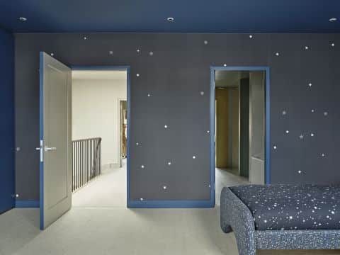 Fun boys bedroom with wallpaper feature sky and stars.