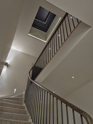 A classic contemporary staircase at night with roof light with recessed light.