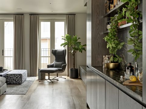Oak floors in London home living and media room. a marble and wood bar is situated in the room as well.