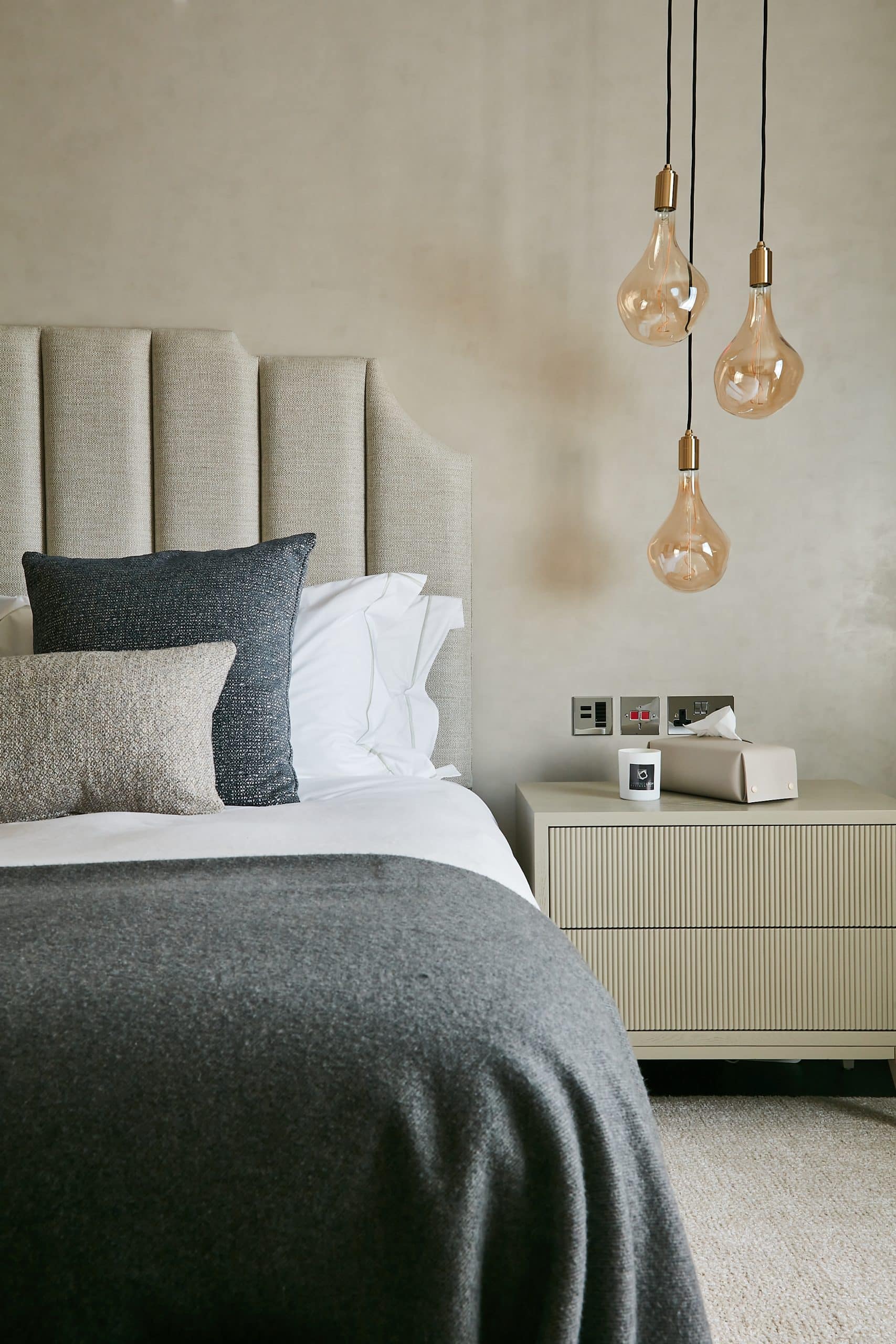 Pendant lights giving a more elevated look to neutral bed.