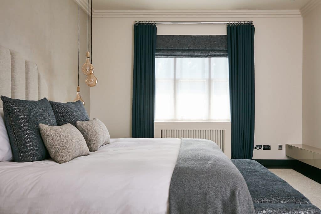Neutral principle bedroom with greyish-blue textiles.
