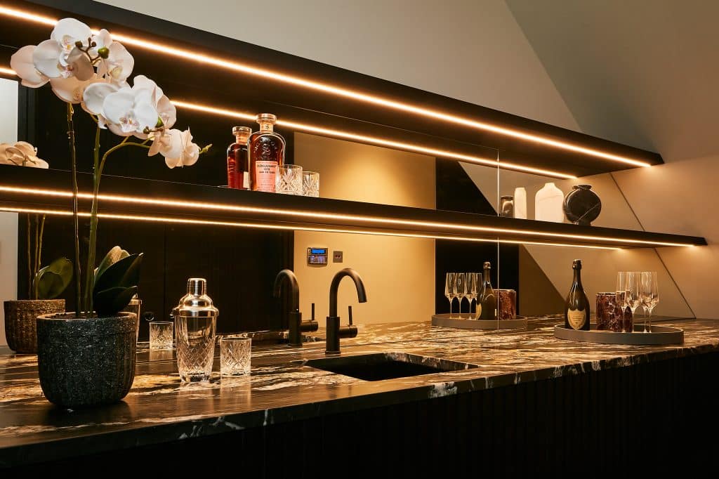 Modern home bar with dark marble countertop.