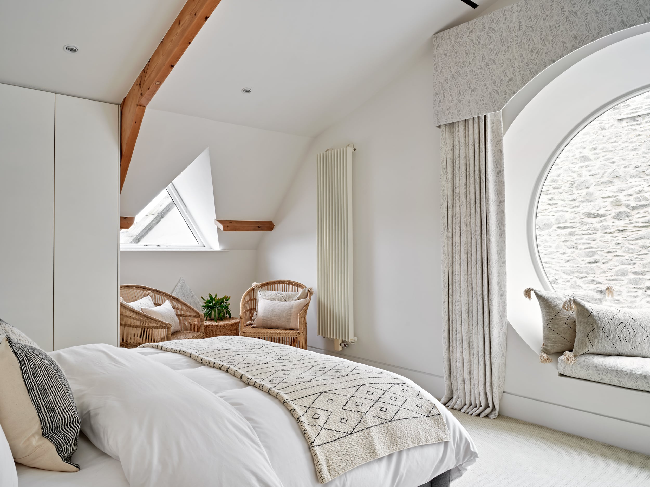 Light and neutral bedroom with reading nook by the window.