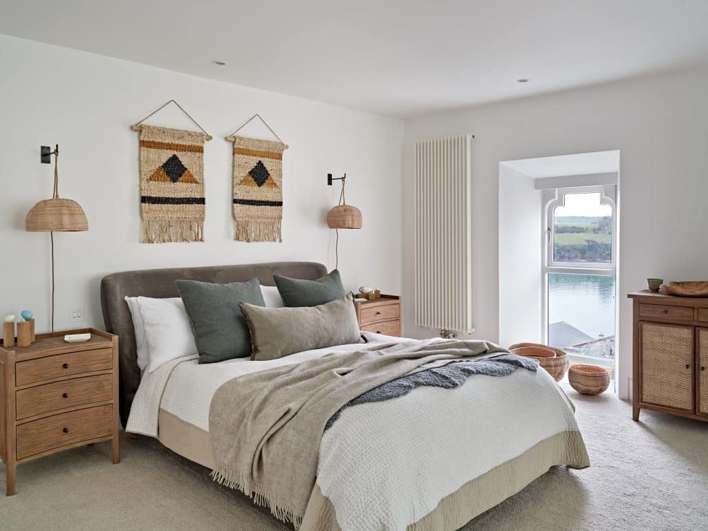 Neutral coastal style principle bedroom with rattan accessories.