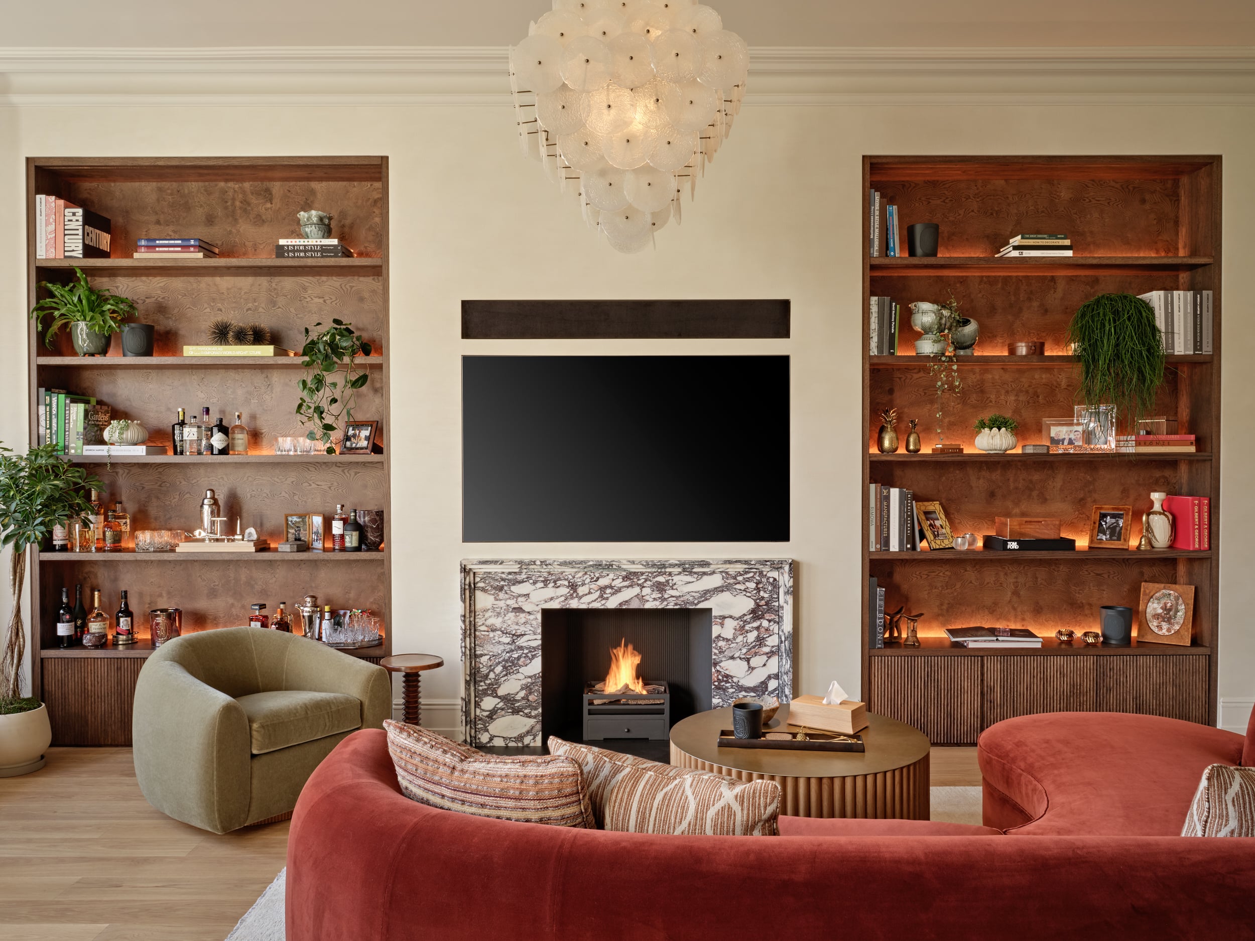 Cozy living space in Central London apartment.On the two sides of the TV and Fireplace there are bespoke shelves displaying sentimental items lovingly collected by the owner.