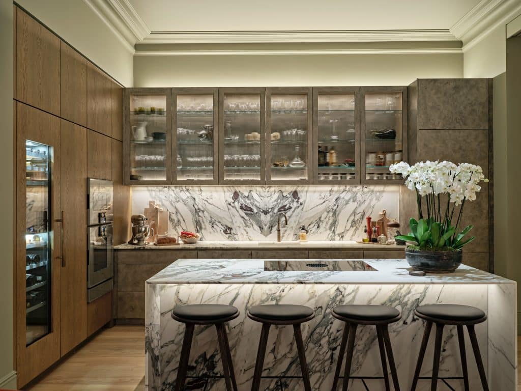 Beautiful marble kitchen with bespoke cabinetry. In the cabinetry there is a wine fridge, steam oven and regular oven.